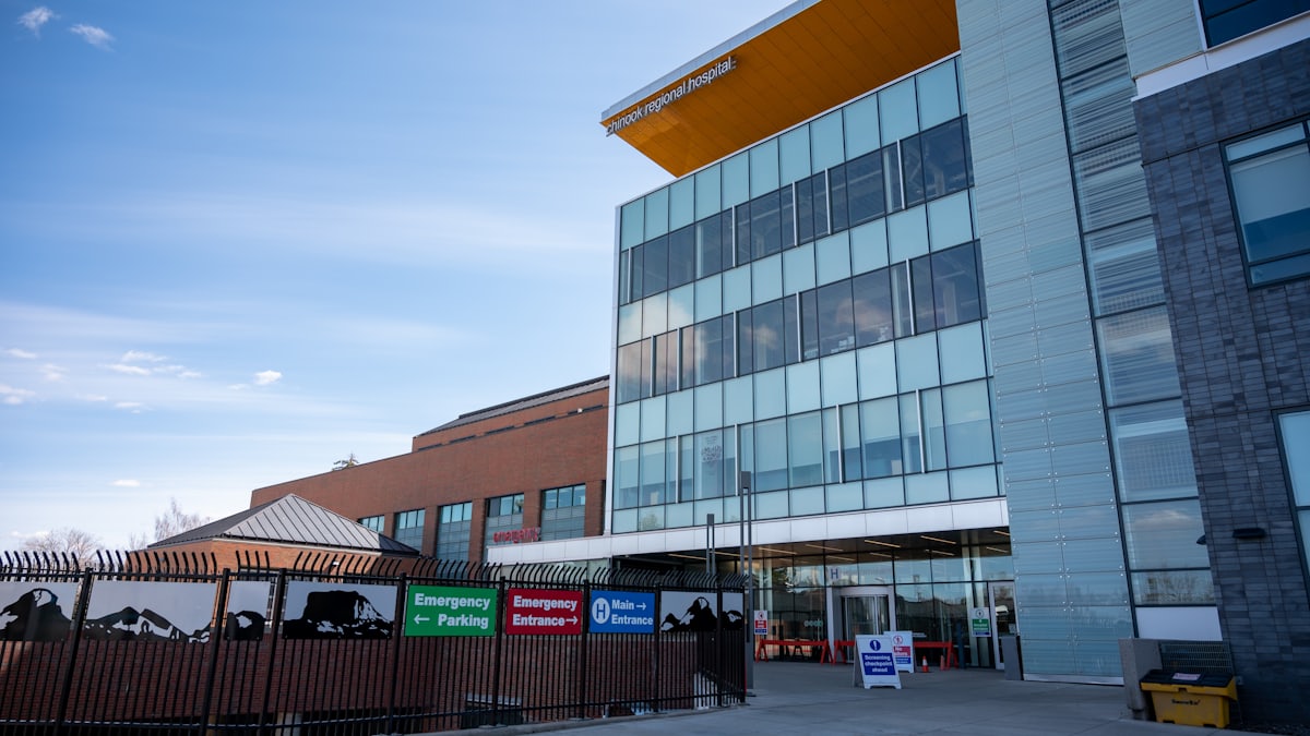 A modern public health clinic building in Canada with clear glass windows under a blue sky.